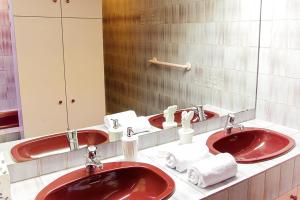 a bathroom with two red sinks and a mirror at Trois Conils - Localisation exceptionnelle 3 chambres 3 salles de bain Parking in Bordeaux