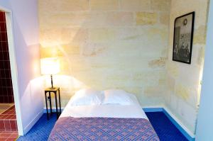 a small bedroom with a bed and a lamp at Trois Conils - Localisation exceptionnelle 3 chambres 3 salles de bain Parking in Bordeaux