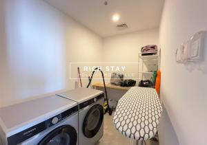 a laundry room with a washing machine and a chair at Harmonious 3BR in Stella Maris, Sea View, Marina in Dubai