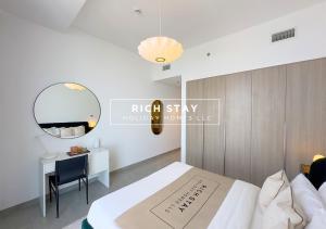 a bedroom with a bed and a desk and a mirror at Harmonious 3BR in Stella Maris, Sea View, Marina in Dubai