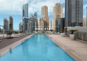 a large swimming pool on top of a city skyline at Harmonious 3BR in Stella Maris, Sea View, Marina in Dubai