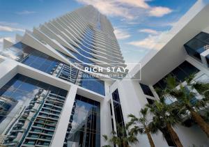 a tall building with palm trees in front of it at Harmonious 3BR in Stella Maris, Sea View, Marina in Dubai