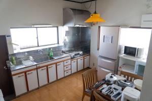 a kitchen with a sink and a table and a refrigerator at 木の家ゲストハウス4号館 in Mito +21 photos
