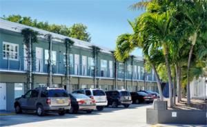 ein Parkplatz mit Autos vor einem Gebäude in der Unterkunft Blue Marlin Motel in Key West