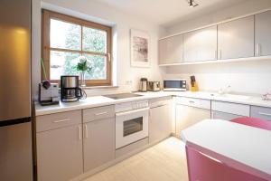 a kitchen with white cabinets and a window at Haus Engel in Pfronten