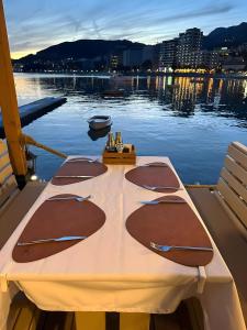 una mesa en un barco en el agua por la noche en Hotel Kuč en Budva