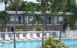 un complejo con piscina, sillas y un edificio en Blue Marlin Motel, en Key West