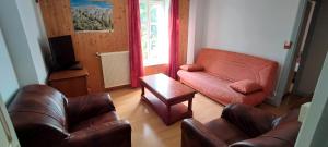 ein Wohnzimmer mit einem Sofa und einem Tisch in der Unterkunft Gîte montagne 1 à 25 places "Chalet Coste Belle" in Ceillac