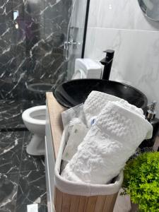 a basket of towels in a bathroom with a sink at APARTAMENT PANORAMIC in Alba Iulia