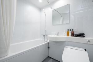 e bagno bianco con vasca, servizi igienici e lavandino. di The One Five Garden Kurashiki - Vacation STAY 96319v a Kurashiki