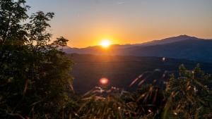 a sunset over a field with mountains in the background at Le Spine B&B sulla Via Francigena in Berceto