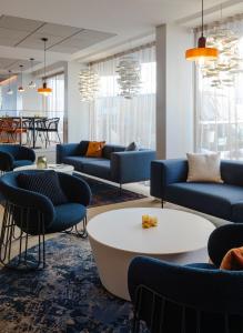 a living room with couches and a table and chairs at Oceania Saint Malo in Saint Malo