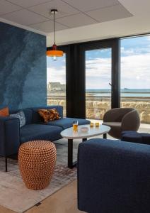 a living room with blue couches and a table at Oceania Saint Malo in Saint Malo