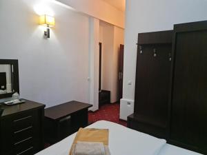 een slaapkamer met een bed, een dressoir en een spiegel bij Hotel Magic GT Trivale in Piteşti