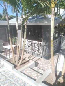 南迪的住宿－Home Away From Home，两棵棕榈树和房子前面的长凳
