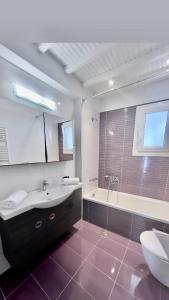 ein Badezimmer mit einer Badewanne, einem Waschbecken und einem WC in der Unterkunft Beautiful apartment in Mykonos town ! in Mykonos Stadt