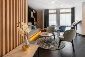 a living room with a vase of flowers on a table at Nemea Appart Hotel Home Suite Nancy Centre in Nancy