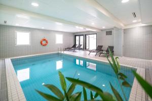una gran piscina con sillas en una habitación en Nemea Appart Hotel Home Suite Nancy Centre en Nancy