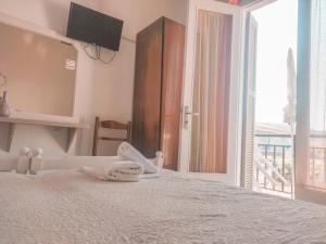 a bedroom with a white bed and a balcony at Hotel Maria in Skala Potamias