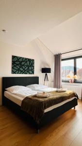 a bedroom with a large bed in front of a window at AMAO-Green I 90qm I Zentrum I Maisonette I Dachterrasse I King-Size Boxspringbetten I EuropaPark in Lahr