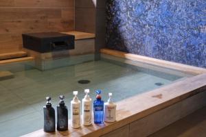 a group of four shampoo bottles sitting in a bath tub at Almont Hotel Sendai in Sendai