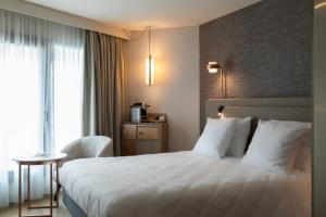 a hotel room with a bed and a window at Oceania Saint Malo in Saint Malo