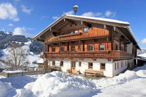 a large wooden house with snow around it at Haus Boarbauer in Kirchberg in Tirol