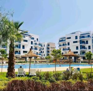 a swimming pool with chairs and umbrellas in a resort at Appartement Costa Mar Martil in Martil