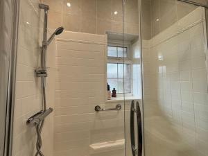 a shower with a glass door in a bathroom at Charming 2BR Cottage - Fully Furnished - 10min LGW - Free Parking in Crawley
