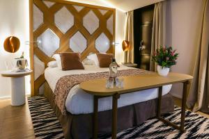 um quarto de hotel com uma cama e uma mesa com flores em Hospes Maricel y Spa, Palma de Mallorca, a Member of Design Hotels em Cas Català