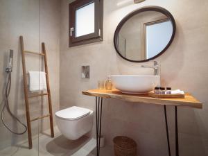 a bathroom with a sink and a mirror and a toilet at Alavastros City Center in Zakynthos +35 photos