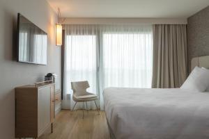 a hotel room with a bed and a chair at Oceania Saint Malo in Saint Malo