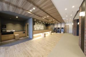 a lobby with a waiting area and a barber shop at Dormy Inn Maebashi in Maebashi