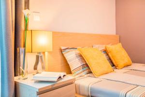 a bedroom with a bed with yellow pillows and a lamp at Villa Royal in Klimno +16 photos