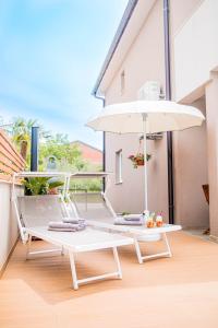 a white chair and an umbrella on a balcony at Villa Royal in Klimno