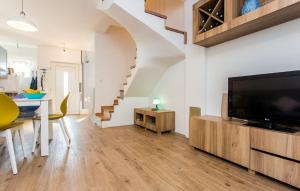 a living room with a flat screen tv and a staircase at Villa Royal in Klimno