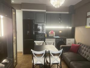a kitchen with a couch and a table and chairs at Himara luxury apartments in Himare