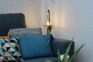 a lamp sitting next to a blue couch with pillows at Le Rétro de la Gare - FloBNB in Laon