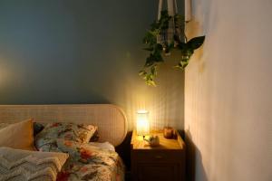 a bedroom with a bed and a lamp on a night stand at Le Rétro de la Gare - FloBNB in Laon
