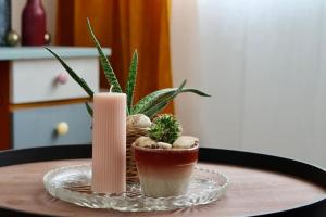 a table with a potted plant and a candle at Le Rétro de la Gare - FloBNB in Laon