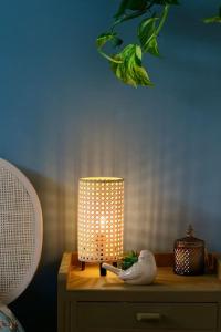 a lamp on a nightstand with a bird on it at Le Rétro de la Gare - FloBNB in Laon