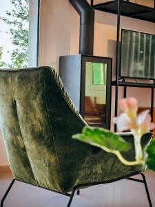 una silla verde con una flor en una habitación en Beit Mema, en Aḑ Ḑahr