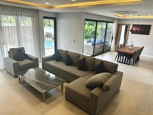 象島的住宿－Zensiri pool villa Koh Chang H1，客厅配有沙发和桌子