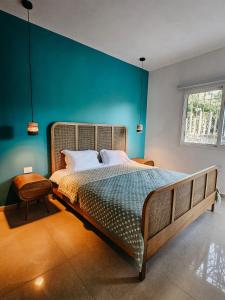 1 dormitorio con 1 cama grande y pared azul en Beit Mema, en Aḑ Ḑahr
