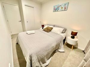 a small bedroom with a bed and a lamp at Nice 3 bedroom Townhouse U2 in Hamilton