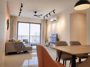 Una sala de estar con mesa y sillas y un comedor. en Family friendly - 3 Bedrooms 6 Pax - Free Parking, en Johor Bahru