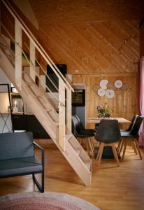 escalera en una sala de estar con mesa y sillas en Kantor Lodges & Chalets, en Millstatt