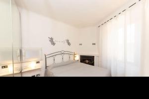 a white bedroom with a bed and a window at Il nido appartamento nel cuore del centro storico in Luino