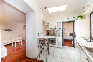 a kitchen and living room with white walls and wood floors at Il nido appartamento nel cuore del centro storico in Luino
