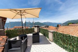 a patio with a table and an umbrella at Il nido appartamento nel cuore del centro storico in Luino